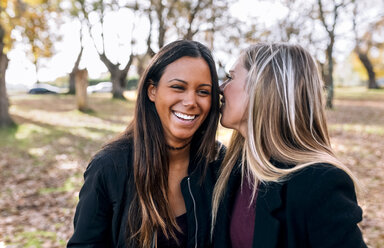 Two happy young women talking in park - MGOF02760