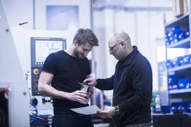 Zwei Männer bei der Arbeit in einer Fabrik - SGF02084