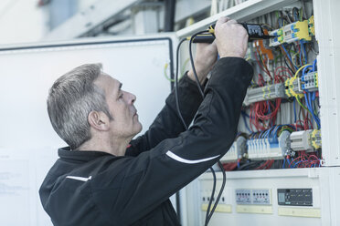 Technician working on switchboard - SGF02094