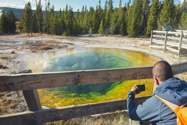 USA, Wyoming, Yellowstone National Park, man taking photos at Morning Glory Pool - EPF00234