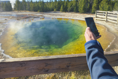 USA, Wyoming, Yellowstone-Nationalpark, Mann beim Fotografieren am Morning Glory Pool, lizenzfreies Stockfoto