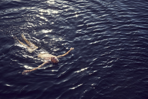 Mann schwimmt im Wasser, lizenzfreies Stockfoto