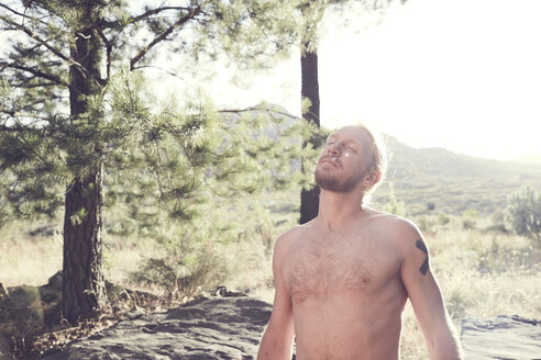 Barechested man with closed eyes in the countryside - SRYF00196