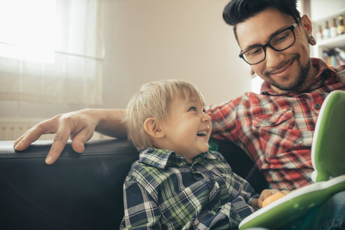 Glücklicher Vater und Sohn mit Spielzeug-Laptop - ZEDF00479