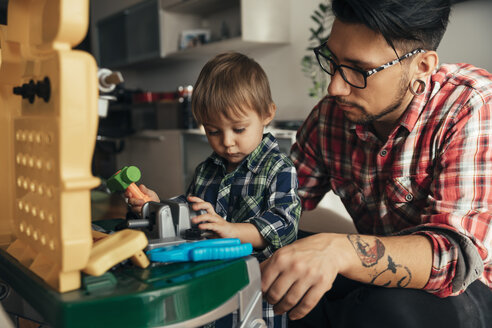 Vater und Sohn spielen zusammen auf einer Spielzeugwerkbank - ZEDF00487