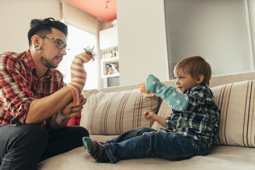 Vater und Sohn spielen zusammen auf der Couch - ZEDF00490