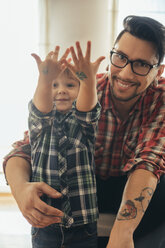 Stolzer Sohn zeigt gemalte Tattoos auf seinen Händen - ZEDF00495