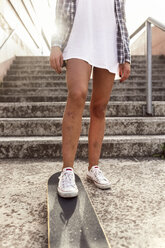 Beine einer jungen Frau mit Skateboard - MGOF02774