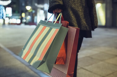 Woman with shopping bags on pavement, partial view - DAPF00531