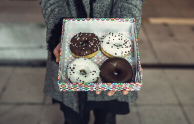 Frau hält Schachtel mit Doughnuts, Teilansicht - DAPF00533