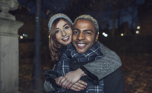 Porträt eines glücklichen jungen Paares vor einem Park - DAPF00538