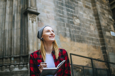 Spain, Barcelona, smiling young woman with notebook - KIJF01054