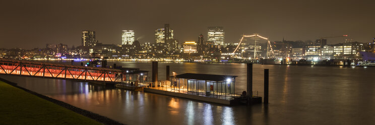 Germany, Hamburg, view to lighted city with Elbe River and ferry dock in the foreground - WIF03387