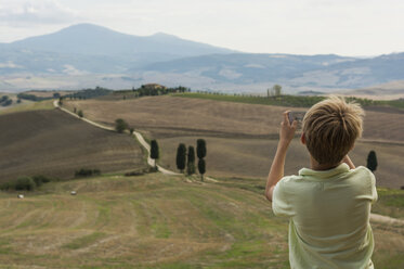 Italien, Toskana, Junge beim Fotografieren der Landschaft - PAF01747