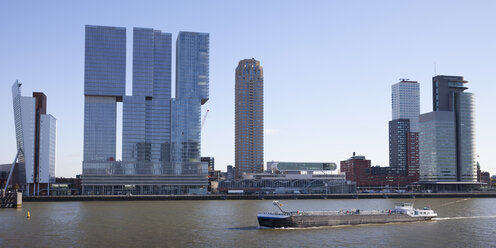 Netherlands, Rotterdam, view to skyline with cargo ship on Meuse River in the foreground - WIF03389