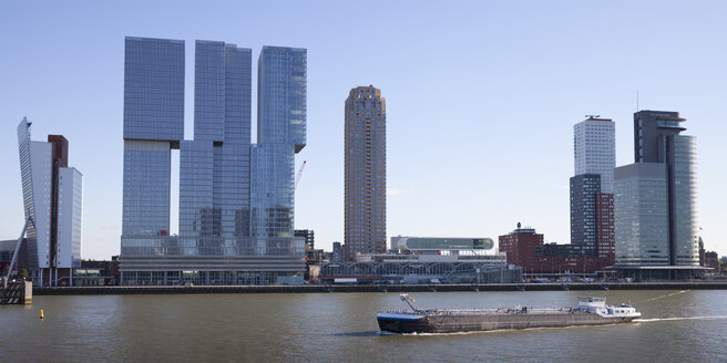 Niederlande, Rotterdam, Blick auf die Skyline mit einem Frachtschiff auf der Maas im Vordergund - WIF03389