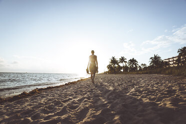 USA, Florida, Key West, Frau geht bei Sonnenuntergang am Strand spazieren - CHPF00361