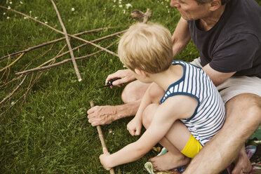 Vater und Sohn spielen mit selbstgebautem Pfeil und Bogen - MFF03421