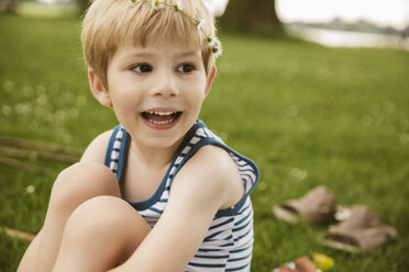 Laughing boy sitting in park - MFF03422