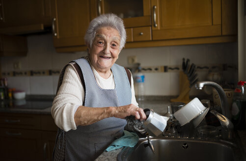 Ältere Frau wäscht Geschirr in der Küche - RAEF01648