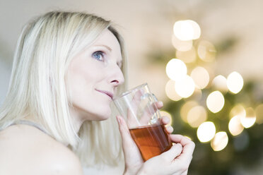 Blonde Frau genießt ein Glas Tee - CHPF00364