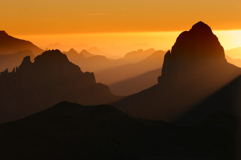Algerien, Wilaya Tamanrasset, Hoggar-Gebirge mit vulkanischem Gestein bei Sonnenaufgang, lizenzfreies Stockfoto