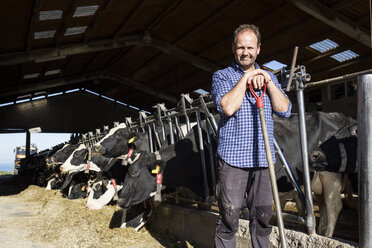 Porträt eines Landwirts mit einer Schaufel auf einer Kuhfarm - ABZF01757
