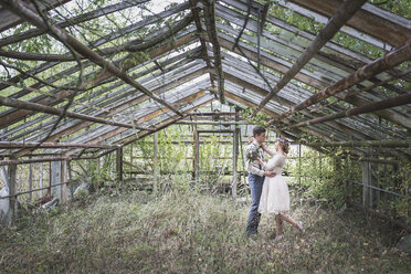 Bride and groom embracing in greenhouse - ASCF00683