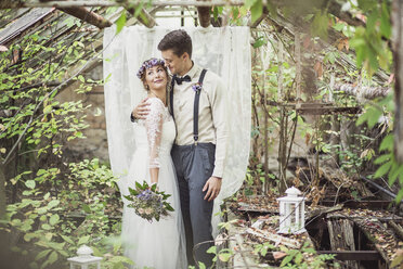 Bride and groom embracing in greenhouse - ASCF00690