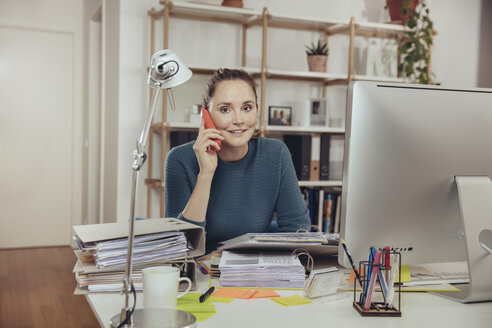 Woman talking on the phone in home office - MFF03424