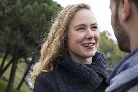 Frau lächelnd mit Blick auf einen Mann im Freien, lizenzfreies Stockfoto