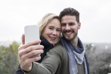 Lächelndes Paar macht ein Selfie im Freien - ABZF01775