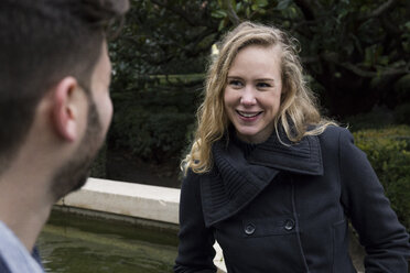 Woman smiling looking at a man in a park - ABZF01788