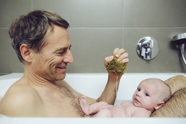 Vater und Baby nehmen ein Bad mit einem Naturschwamm - MFF03439