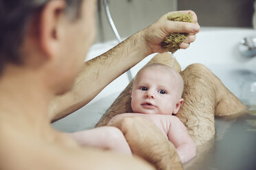 Vater und Baby nehmen ein Bad mit einem Naturschwamm - MFF03440