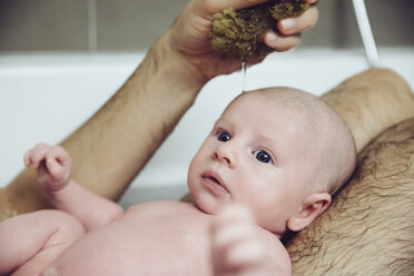 Vater und Baby nehmen ein Bad mit einem Naturschwamm - MFF03441