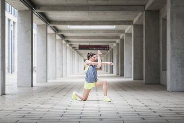 Woman stretching at arcade - ASCF00712