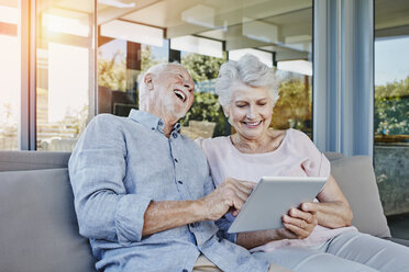 Älteres Paar sitzt auf der Terrasse und benutzt ein digitales Tablet - RORF00443