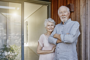 Ein älteres Ehepaar steht vor seinem Haus und sieht zuversichtlich aus - RORF00451