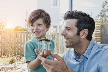 Father and son catching together a cricket - RORF00466