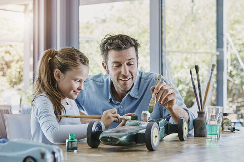 Father and daughter painting a toy race car - RORF00478