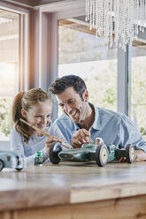 Father and daughter painting a toy race car - RORF00480