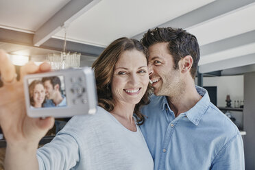 Ein glückliches Paar, das sich in seiner Wohnung fotografiert - RORF00513