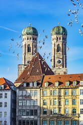 Deutschland, München, Blick auf die Türme des Doms zu Unserer Lieben Frau mit Häusern und Vogelschwarm im Vordergrund - THA01880