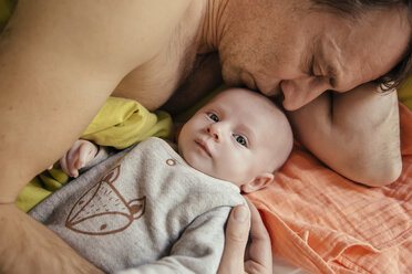 Vater kuschelt im Bett mit seinem neugeborenen Baby - MFF03456