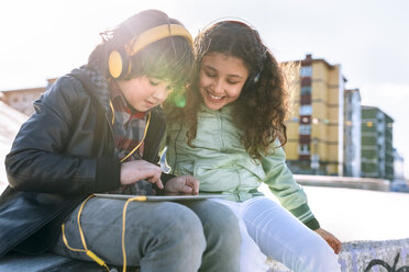 Zwei Kinder mit Kopfhörern und Tablet - MGOF02792