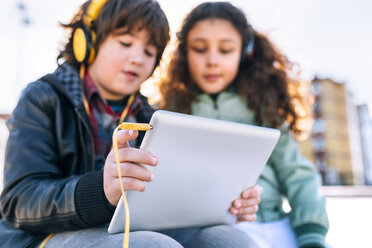 Zwei Kinder hören Musik mit Kopfhörern und Tablet - MGOF02793