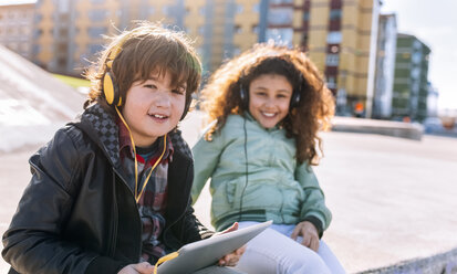 Two children listening music with headphones and tablet - MGOF02794