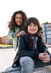 Portrait of smiling boy with his girlfriend in the background - MGOF02799