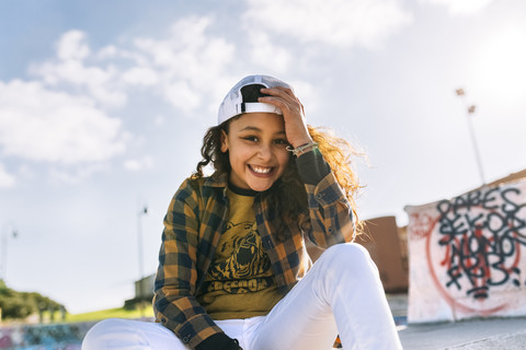 Porträt eines lächelnden Mädchens mit Baseballmütze, lizenzfreies Stockfoto